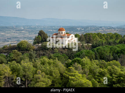 Die Kirche im Dorf von Pano Theletra sitzt auf einer erhöhten Position, umgeben von Bäumen. Stockfoto