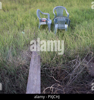 Drei Plastikstühle auf einem Patch von Gras in Alpine, Texas. Stockfoto