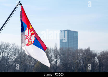 Foto der offizielle Flagge der Republik Serbien, vor einem Geschäft Gebäude in Belgrad, Serbien, mit einem Hintergrund von blauem Himmel und Wolken Pi Stockfoto