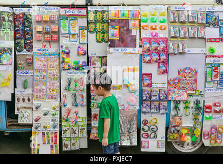 Junge schaut auf Spielzeug für Verkauf an den umgebauten VW-Transporter pop up Toy Shop am Markt JingJai Farmer's, Chiang Mai, Thailand Stockfoto