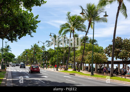 Die schöne Kalakaua Avenue mit Palmen gesäumt von Kokospalmen und dem Strand in Waikiki beach Honolulu Hawaii am 5. Oktober 2018 Stockfoto