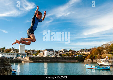 Schull, West Cork, Irland. 23 Okt, 2018. Daniel Copithorne von Ballydehob macht die meisten der ungewöhnlich warmen Wetter durch einen Sprung ins Meer aus Schull Pier. Sunshine hat die Reihenfolge der Tag heute mit Höhen von 13-15° Celsius in West Cork. Credit: Andy Gibson/Alamy Leben Nachrichten. Stockfoto