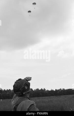 Herr Darrin Courtney, ein D-Day reenactor, stellt einen Fallschirm drop entlang Purple Heart Lane aus einem Jahrgang C-47 Skytrain in Carentan, Frankreich, am 2. Juni 2017. Purple Heart Lane ist ein Spitzname für die Autobahn N 13 von amerikanischen Soldaten und Historiker zu einem Schlachtfeld, auf dem Oberstleutnant Robert G. Cole und seine Truppen der Luftlandedivision während der Schlacht in der Normandie im Zweiten Weltkrieg kämpfte kennzeichnen Dieses Ereignis erinnert an den 73. Jahrestag des D-Day, dem größten multi-nationalen amphibische Landung und operativen militärischen Airdrop in Geschichte und Highlights der USA' unerschütterliche Verpflichtung zu Eu Stockfoto