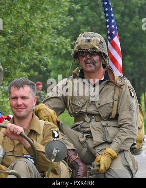 D-Day reenactors beobachten, ein Fallschirm drop entlang Purple Heart Lane aus einem Jahrgang C-47 Skytrain in Carentan, Frankreich, am 2. Juni 2017. Purple Heart Lane ist ein Spitzname für die Autobahn N 13 von amerikanischen Soldaten und Historiker zu einem Schlachtfeld, auf dem Oberstleutnant Robert G. Cole und seine Truppen der Luftlandedivision während der Schlacht in der Normandie im Zweiten Weltkrieg kämpfte kennzeichnen Dieses Ereignis erinnert an den 73. Jahrestag des D-Day, dem größten multi-nationalen amphibische Landung und operativen militärischen Airdrop in der Geschichte, und hebt die USA "unerschütterlichen Verpflichtung gegenüber den europäischen Verbündeten und partne Stockfoto