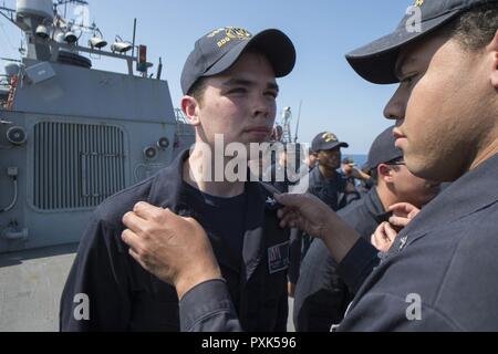 Mittelmeer (1. Juni 2017) - Elektroniker 2 rd Klasse James Beyer hat seinen zweiten Klasse Petty Officer Krähen, die ihm durch Elektronik Techniker 2 rd Klasse Josua Burgess während der Werbeaktion Zeremonie an Bord der Arleigh-Burke-Klasse festgesteckt geführte Anti-raketen-Zerstörer USS Carney (DDG64) im Mittelmeer 1. Juni 2017. Carney, Vorwärts - Rota, Spanien bereitgestellt werden, ist die Durchführung der dritten Patrouille in den USA 6 Flotte Bereich der Maßnahmen zur Unterstützung der US-amerikanischen nationalen Sicherheitsinteressen in Europa. Stockfoto