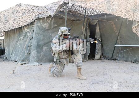 Staff Sgt. Ray Gill, das dem Unternehmen zugewiesen wurde, B, 150 Techniker Bataillon, Mississippi Army National Guard, nimmt Stellung zu kämpfen Eintrag einer taktischen Operationen verhindern Mitte Juni 3, 2017, in Fort Irwin, Kalifornien. (Mississippi Stockfoto