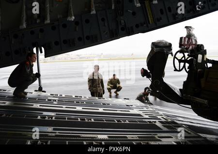 Senior Airman Lauren Sheppard (links), eine C-17 Globemaster III Mannschaft Mitglied der 535th Airlift Squadron, 15 Flügel, Erdgeschoss führt eine Light Medium tactical Vehicle (LMTV), lädt es eine M777A2 155mm Howitzer an Bord einer C-17 an Wheeler Army Airfield, Hawaii, am 1. Juni 2017. Soldaten und Ausrüstung aus dem 3 Bataillon, 7 Field Artillery Regiment, 25 Abteilung Artillerie, 25 Infanterie Division. Usa (Armee Stockfoto