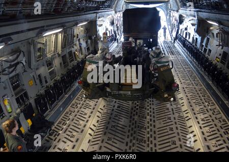 Senior Airman Lauren Sheppard (links), eine C-17 Globemaster III Mannschaft Mitglied der 535th Airlift Squadron, Boden führt eine Light Medium tactical Vehicle (LMTV), lädt es eine M777A2 155mm Howitzer an Bord einer C-17 an Wheeler Army Airfield, Hawaii, am 1. Juni 2017. Soldaten und Ausrüstung aus dem 3 Bataillon, 7 Field Artillery Regiment, 25 Abteilung Artillerie, 25 Infanterie Division. Usa (Armee Stockfoto