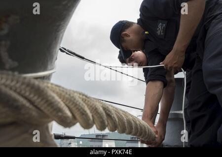 WHITE BEACH, Okinawa (5. Juni 2017) Seaman Eric Rosser (vorne), von Waldorf, Md., und Aviation Ordnanceman Airman David Gaona, aus Costa Mesa, Kalifornien, sichere Verankerung an einem Poller im Meer und anker detail an Bord der Amphibisches Schiff USS BONHOMME RICHARD (LHD6) als das Schiff zu weißen Strand Marinestützpunkt ankommt einzuschiffen Marines der 31 Marine Expeditionary Unit (MEU). Während der Begehung, das Schiff wird 31 MEU Personal, Fahrzeuge und Geräte, bevor Sie eine geplante Patrouille. Bonhomme Richard, dem Flaggschiff der Bonhomme Richard amphibischen bereit, Gruppe, ist auf einer routi Stockfoto