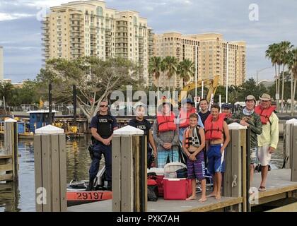 Coast Guard Besatzungsmitglieder von Station Cortez und die sechs Leute, die sie gerettet für ein Bild Sonntag, 4. Juni 2017 auf der 10. Straße Boot Rampe in Sarasota, Florida dar. Die Gruppe wurde gerettet, nachdem ihr Boot begann, auf dem Wasser in der Nähe von neuen Pass Einlass. Stockfoto