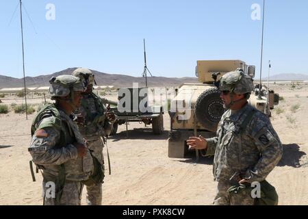 Sgt. Grenilo Caspillan, und Kapitän Tom Roberson, zum Hauptquartier Firma zugewiesen, 150 Techniker Bataillon, Mississippi Army National Guard, deren Personal status Zahlen diskutieren, 2. Juni 2017, am National Training Center. (Mississippi Stockfoto