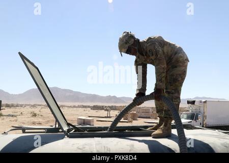 Pfc. James Warren, ein zu Unternehmen A, 106 Support Bataillons, Mississippi Army National Guard zugeordnet, füllt ein Wasserbüffel mit gereinigtem Wasser Juni 5, 2017, in der National Training Center. (Mississippi Stockfoto