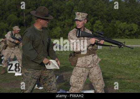 Us Marine Corps Sgt. Max Tackett, primäre Treffsicherheit Instructor, Waffen und Ausbildungsmaßnahmen Bataillon, rekrutieren Training Regiment, beauftragt Rct. Jakob Jelesiewicz, platoon 2050, Hotel Company, 2 Bataillon, in Hue City auf Marine Corps Depot rekrutieren, Parris Island, S.C., 6. Juni 2017. Qualifying mit der M16-A4-Gewehr lehrt Rekruten das Waffensystem zu verstehen, um mit dem Konzept 'zu halten jeder Marine ein Rifleman." Stockfoto