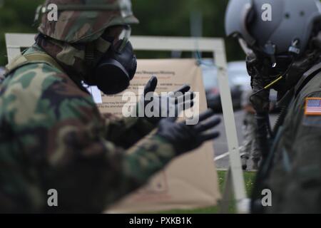 Us Air Force 1 Lt Beau Deleon, Recht, ein Pilotprojekt mit der 108 Flügel, ist durch das Bordpersonal Kontaminationskontrolle Bereich während einer Übung am Joint Base Mc Guire-Dix - Lakehurst, New Jersey, 7. Juni 2017 verarbeitet. Dieses Bild wurde mit einem Tilt-shift Objektiv aufgenommen. Stockfoto