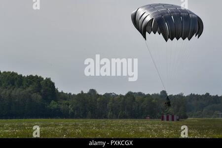 Ein container Delivery System Bundle auf den Boden fällt, nachdem aus der US Air Force C-130J Hercules während der Übung Super Sabre Streik 17 auf lielvārde Air Base, Lettland, 7. Juni 2017. Die 435Th Contingency Response Group von der 435th Air Ground Operations Wing an der Air Base Ramstein, Deutschland, ließ die Bündel voller Ausrüstung zu üben Bewertung ein Bereich für Flugzeuge Landungen. Sabre Streik 17 weiterhin teilnehmenden Kapazität Nationen ein breites Spektrum an militärischen Operationen zu erhoehen. Stockfoto