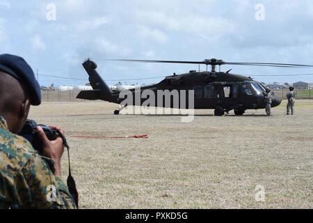 Ein Seemann, der von der Königlichen Bahamas Defence Force (RBDF) Fotos Florida Army National Guard Soldaten zu B-Company, 1-185 th Assault Helicopter Bataillon zugeordnet, nachdem sie ihren UH-60L Black Hawk Hubschrauber verlassen Sie nach Ihrer Landung am Paragon Base. Die Einheit besucht Paragon Basis in einer Tradewinds 2017 Community Relations (COMREL), begrüßte die örtlichen Schule Kinder mit Angehörigen der Streitkräfte aus mehreren Ländern zu treffen, Fragen zu stellen, sich zu beteiligen, und schauen Sie sich Ihre Ausrüstung ganz nah. Tradewinds ist eine gemeinsame, kombinierte Übung in Verbindung mit Partner Nationen geleitet zu en Stockfoto