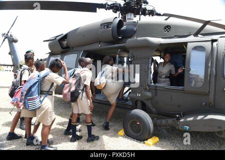 3 Schüler aus Combermere Schule klettern in ein UH-60L Black Hawk Hubschrauber aus Florida Army National Guard B-Company, 1-185 th Assault Helicopter Bataillon, an Bord von Barbados Paragon Base. Die Studenten besuchten die Basis in einer Tradewinds 2017 Community Relations (COMREL) Fall, dass erlaubt lokalen Schule Kinder mit Angehörigen der Streitkräfte von mehreren teilnehmenden Ländern zu Treffen teilzunehmen, sie zu befragen, und schauen Sie sich Ihre Ausrüstung ganz nah. Tradewinds ist eine gemeinsame, kombinierte Übung in Verbindung mit Partnerstaaten durchgeführt, um die kollektiven Fähigkeiten der defens zu verbessern Stockfoto