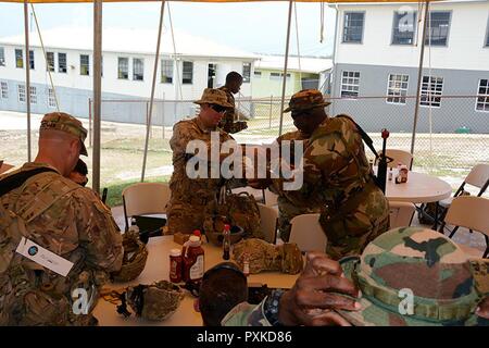 Sgt. 1. Klasse Samuel Amador, ein Infanterist mit dem 1/124 th Infanterie Regiment, 83rd Infantry Brigade Combat Team, Florida Army National Guard, vertreibt Ausbildung Munition zu einem Mitglied der Barbados Defence Force, die in Tradewinds 2017 Paragon Base, Barbados, 8. Juni 2017 beteiligt ist. Tradewinds ist eine gemeinsame, kombinierte Übung in Verbindung mit Partnerstaaten durchgeführt, um die kollektiven Fähigkeiten der Streitkräfte und constabularies zur Verbesserung der grenzüberschreitenden organisierten Kriminalität zu begegnen, und Humanitäre/Katastrophenhilfemaßnahmen zu führen. Stockfoto