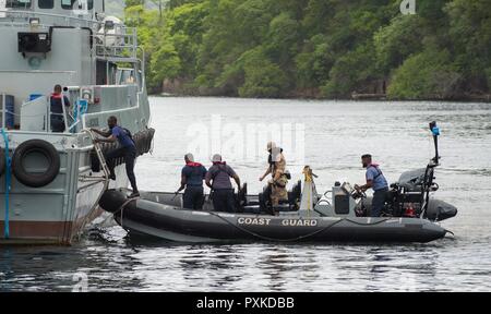 PORT OF SPAIN, Trinidad - ein Mitglied der Maritimen taktische Gruppe Bediener (MTOG) beobachtet die Mitglieder der Trinidad und Tobago Küstenwache (TTCG), da sie eine simulierte Schiff von Interesse, beim Boarding Training am TTCG Basis in Chaguaramas, Trinidad als Teil der Übung TRADEWINDS 17 Am 8. Juni 2017 vorbereiten. (Canadian Forces Combat Kamera Stockfoto