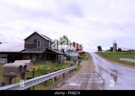 Nasse Straße durch Amish Country an einem bewölkten Morgen in Berlin, Ohio Stockfoto