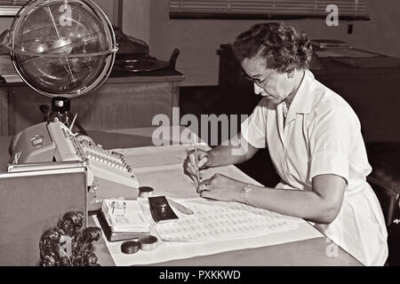 Katherine Johnson, NASA Forschung Mathematiker, an ihrem Schreibtisch bei der NASA Langley Research Center mit einer Kugel, oder "himmlischen Training Device", 1962. Stockfoto