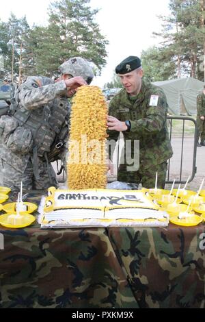 Oberstleutnant Jason Benson mit dem Th 2-136 kombinierte Waffen Bataillon erhält eine traditionelle litauische Kuchen zu Ehren der US-Armee 242nd Geburtstag Juni 14, 2017 in Pabrade, Litauen. Kroatisch, Niederländisch, Norwegisch, Litauisch, Deutsch, Portugiesisch und Army National Guard Kräfte aus Pennsylvania und Minnesota schlossen sich ihnen auch während der Feier während der Übung Iron Wolf 17. Stockfoto