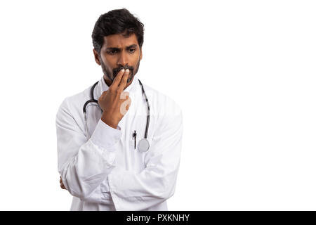 Konzentriert man den Blick von dem indischen Arzt mit den Fingern berühren Lippen, als sich wundern Konzept auf weißem studio Hintergrund isoliert Stockfoto