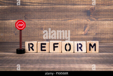 Reform Konzept. Holz- briefe mit Schild auf Holz- Hintergrund Stockfoto