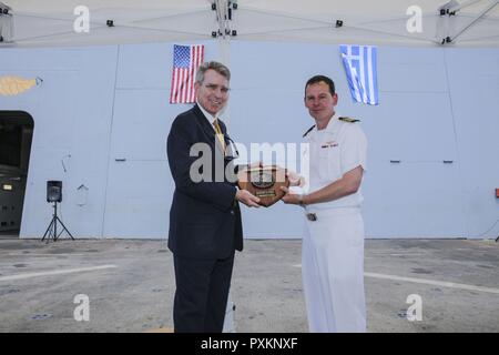 Piräus, Griechenland (13. Juni 2017) Kapitän Max Clark, kommandierender Offizier der San Antonio-Klasse amphibious Transport dock Schiff USS Mesa Verde LPD (19), stellt eine Plakette zu Geoffrey Pyatt, US-Botschafter in Griechenland, während eines geplanten Besuch Juni 13, 2017. Das Schiff ist, implementiert mit der bataan Amphibious Ready Gruppe und 24 Marine Expeditionary Unit Maritime Security Operations und Theater Sicherheit Zusammenarbeit in den USA 6 USA 5 Flotte Flotte und Bereiche der Aktivitäten zu unterstützen. Stockfoto