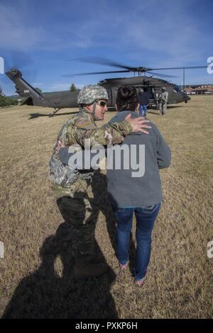 Us-Armee Master Sgt. Mike Dotson, Crew Chief mit Joint Force Head Quarters, South Dakota Army National Guard spricht mit Kim Vanneman Mitglied der South Dakota der militärischen Angelegenheiten, bevor ein HH-60 M MEDEVAC Black Hawk Verpflegung während der Goldenen Coyote Übung in Rapid City, S.D., 15. Juni 2017. Die goldenen Coyote Übung ist eine dreiphasige, Szenario-driven Übung in den Black Hills von South Dakota und Wyoming, mit dem Kommandanten auf der Mission wesentliche Anforderungen der Aufgabe, Krieger Aufgaben und Übungen zu konzentrieren. Stockfoto