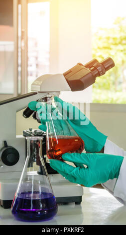 Labor Becher in der Analyst Hand in Kunststoff Handschuh Stockfoto