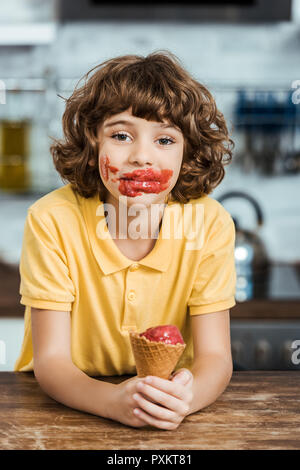 Adorable Junge mit Eis auf dem Gesicht halten, leckeres Eis und Kamera Stockfoto