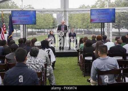 NEW YORK - John E. Thompson, der Bezirk Direktor der U.S. Citizenship und Immigration Services, spricht mit den Mitgliedern der Einbürgerung Zeremonie ihre Staatsbürgerschaft erhalten an vier Freiheiten Park auf Roosevelt Island in New York, 16. Juni 2017. Mitglieder von Marine Corps Band New Orleans nahm ebenfalls an der Zeremonie durchzuführen, "Die Star-Spangled Banner" und das Marine Corps Reserve Centennial Concert später geschieht, die Nacht im Park zu fördern. Stockfoto