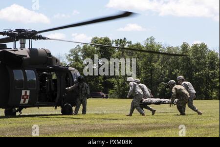 Soldaten der 108 Bereich Medizinische Gesellschaft zugeordnet, 213 Region Support Group, Pennsylvania Army National Guard, laden Sie einen simulierten Unfall in ein UH-60 Black Hawk Hubschrauber von Soldaten mit loslösung 2, Charlie Company, 2.Staffel, 104 Regiment, 28 Combat Aviation Brigade, Pennsylvania Army National Guard betrieben während der Durchführung wurf Training am Fort Indiantown Gap Juni 9, 2017. Stockfoto