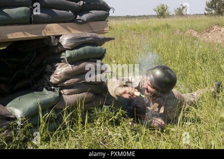 Der Soldat mit der Ukraine 1 Airmobile Bataillon, 79 Air Assault Brigade wirft eine Granate in einen Bunker während Platoon Bewegung und Angriff bohrt mit der yavoriv Combat Training Center. Yavoriv CTC Personal, zusammen mit Mentoren aus 45Th der US Army Infantry Brigade Combat Team, führte die Ausbildung von Soldaten aus dem 1-79 Th während der Drehung des Bataillon durch die YAVORIV CTC. Der 45. ist in der Ukraine als Teil des Gemeinsamen multinationalen Ausbildung Group-Ukraine, eine internationale Koalition für eine Verbesserung der Ausbildung der Fähigkeit des CTC und Professionalität in der Ukr bereitgestellt Stockfoto