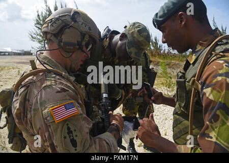 Barbadian Defence Force Mitglieder Plan der beste Weg ein Solarkraftwerk mit einer Florida Army National Scots Guards bei Tradewinds 2017, 8. Juni verteidigen. Stockfoto