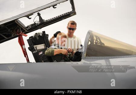 Oregon Air National Guard Kapitän Aaron Lamont, zu der 123 Fighter Squadron zugeordnet, 142 Fighter Wing, bereitet für einen Nachmittag Flug in einem F-15 Eagle mit Unterstützung der Crew Chief Tech. Sgt. Jason Thompson, an der Nellis Air Force Base, Nev, bei einem der Waffeninspektionen Kurs, 8. Juni 2017 zu unterstützen. Stockfoto