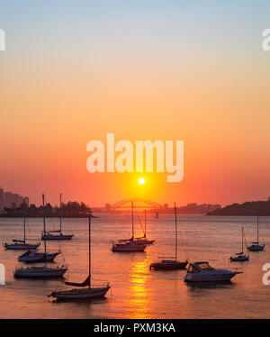 Ein schöner Sonnenuntergang über die Sydney Harbour Bridge spiegelt sich in den ruhigen Gewässern der Einsiedler Bucht in Vaucluse. Von der Eremitage Vorland gesehen zu Fuß Stockfoto