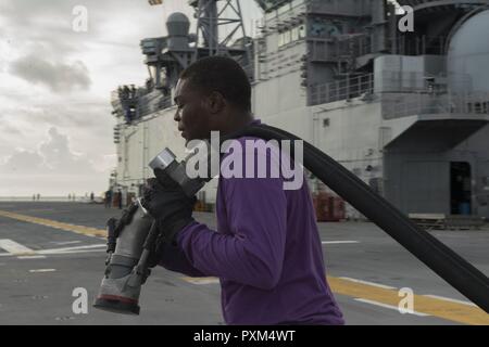 MAYPORT, Fla (11. Juni 2017) der Luftfahrt Bootsmann Mate (Kraftstoff) Airman Kenneth Kountz bereitet einen Schlauch für den Flugbetrieb auf dem Flugdeck des Amphibious Assault ship USS Iwo Jima (LHD7). Iwo Jima befindet sich derzeit in einer Reihe von Zertifizierungen in Vorbereitung für künftige Operationen und Bereitstellungen. Stockfoto