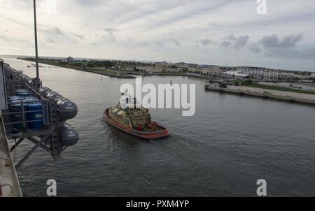 MAYPORT, Fla (11. Juni 2017) eine Tug Boat unterstützt die Amphibious Assault ship USS Iwo Jima (LHD7), als sie aus ihrem Heimathafen zieht an Naval Station Mayport. Iwo Jima befindet sich derzeit in einer Reihe von Zertifizierungen in Vorbereitung für künftige Operationen und Bereitstellungen. Stockfoto