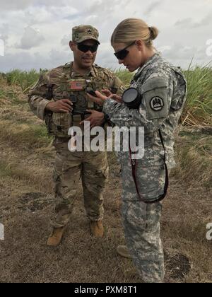 Louisiana Army National Guard Sgt. Renee Seruntine, einer New Orleans native auf den 241 Mobile Public Affairs Abteilung zugeordnet, Interviews Florida Army National Guard Staff Sgt. Sergio Valdes, ein Miami, Florida native C Company, 1.BATAILLON, 124 Infanterie, 53rd Infantry Brigade Combat Team zugewiesen, über die Beaufsichtigung einer inszenierten Aufruhr, der half, vorzubereiten, Antigua, St. Lucia, St. Vincent und Grenada Polizisten während der Übung Tradewinds 2017 in Bushy Park, Barbados, 10. Juni 2017 zu einem echten Aufstand zu reagieren. Militär und Zivilisten aus 20 Ländern beteiligen sich an der diesjährigen exercis Stockfoto