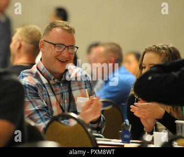 Spezialist Reed Kuhnley, vom Fargo, North Dakota-basierte 461St Ingenieur, Aktien ein Lachen mit seinem Tisch während der Gelbe Band Veranstaltung in Bloomington, Minnesota Juni 10. Kuhnley und die anderen Soldaten des 461St Ingenieur Unternehmen kam vor kurzem von einem Einsatz zur Unterstützung der Operation Spartan Schild und beteiligen sich an der nach der Bereitstellung Teil der Gelbe Band Programm. Stockfoto