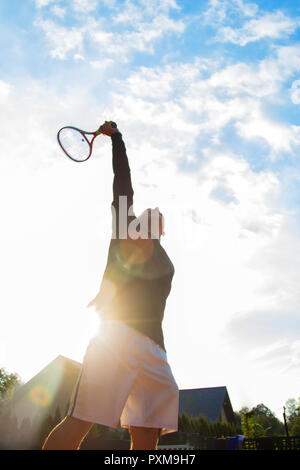 Professional Tennis Player spielen Sie eine Partie Tennis auf einem Gericht. Er ist über den Ball mit dem Schläger zu treffen. Stockfoto