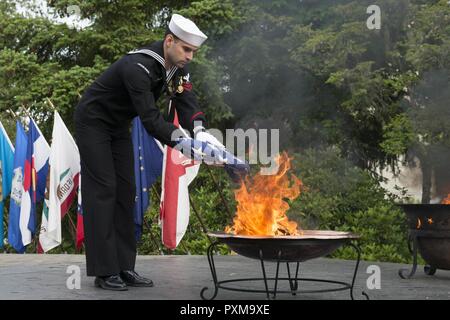 BANGOR, Washington (14. Juni 2017) Sonar Techniker (U-Boote) 1. Klasse Emilio Nardi, von Pittsburg, Pennsylvania, zu Trident Training Service Bangor zugeordnet, Orte die Überreste eines US-Flagge zu einem Brand während einer Flagge in den Ruhestand Zeremonie am Marinestützpunkt Kitsap - Bangor. Wenn eine US-Flagge abgenutzt, zerrissen, blasse oder stark verschmutzt, die Flagge mit der Würde und Achtung, die es in den Ruhestand versetzt. Die traditionelle Methode ist die Fahne in Stücke zu schneiden, trennen die 13 Streifen von Kanton und verbrennen Sie separat in einer respektvollen Weise. Stockfoto