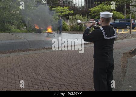 BANGOR, Washington (14. Juni 2017) Musiker 3. Klasse Michael Brehm, von Houston, Texas, zur Marine Band Nordwesten zugeordnet, die Trompete spielt, während eine Flagge in den Ruhestand Zeremonie am Marinestützpunkt Kitsap - Bangor. Wenn eine US-Flagge abgenutzt, zerrissen, blasse oder stark verschmutzt, die Flagge mit der Würde und Achtung, die es in den Ruhestand versetzt. Die traditionelle Methode ist die Fahne in Stücke zu schneiden, trennen die 13 Streifen von Kanton und verbrennen Sie separat in einer respektvollen Weise. Stockfoto