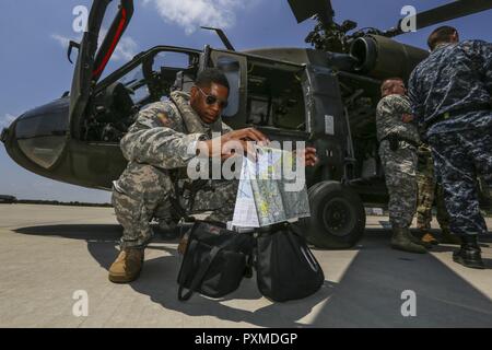 U.S. Army National Guard Kapitän Andre Stevenson, ein Black Hawk Pilot mit der 1-150 th Assault Helicopter Bataillon, schaut über Karten vor einem trainingsflug am Joint Base Mc Guire-Dix - Lakehurst, New Jersey, 14. Juni 2017. Stockfoto