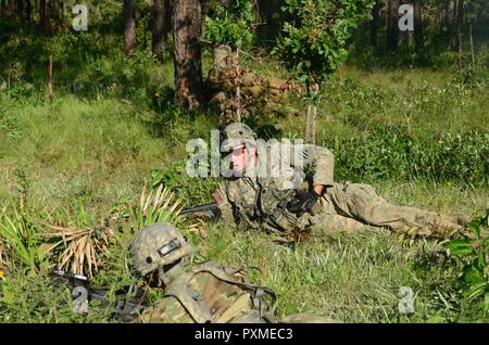 Ein Soldat von dritten Bataillon, 121 Infanterie Regiment, 48th Infantry Brigade Combat Team lädt Munition während der Live-fire Übung Juni 15, 2017 at Fort Stewart, Ga als Teil der exportierbaren Kampftraining Fähigkeit rotation. Stockfoto