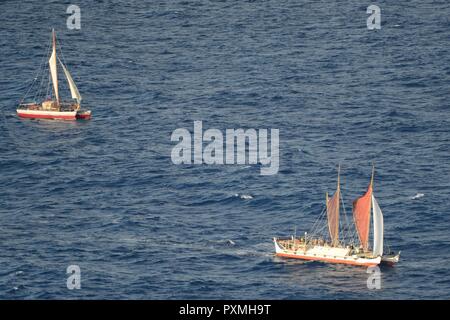 Besatzungsmitglieder auf einem MH-65 Dolphin Hubschrauber von Coast Guard Air Station Herrenfriseure Point, Oahu, führen Sie eine Fliege über Der Hōkūleʻa, eine polynesische Doppelwandiger voyaging Kanus, 16. Juni 2017. Die Hōkūleʻa nach Hause zurück zu Oahu, 17. Juni nach für 36 Monate gegangen sein, Segeln rund 40.000 Seemeilen rund um die Welt. Stockfoto