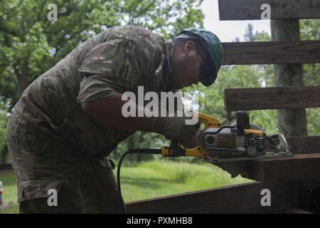 Lance Cpl. Al Frederiksen, 3. Bau Bataillon, Dänische Armee, macht einen Schnitt mit einem rotierenden sah für den Bau einer Fußgängerbrücke im Custer State Park in Unterstützung der Goldenen Coyote Übung, Custer, S.D. Juni 16th, 2017. Die goldenen Coyote Übung ist eine dreiphasige, Szenario-driven Übung in den Black Hills von South Dakota und Wyoming, mit dem Kommandanten auf der Mission wesentliche Anforderungen der Aufgabe, Krieger Aufgaben und Übungen zu konzentrieren. Stockfoto