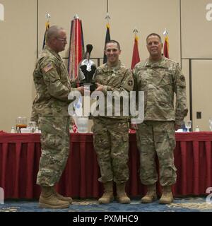 U.S. Army Reserve Non-Commissioned Officer des Jahres, Cpl. Carlo Deldonno (Mitte) als Vertreter der 3. Medizinischen Befehl Bereitstellung unterstützen, hält die besten Krieger Trophäe Helm mit US Army Reserve Command Sgt. Maj. Ted Copeland (links) und Generalmajor Scottie Dekan Zimmermann, der Kommandant der 84 Ausbildung Befehl, während 2017 U.S. Army Reserve Bester Krieger Wettbewerb Preisverleihung im Iron Mike Conference Center, Ft gehalten. Bragg, N.C. Juni 16. In diesem Jahr besten Krieger Wettbewerb bestimmt die obere Unteroffizier und Junior Soldat Soldat der US-Armee Res darstellen, Stockfoto